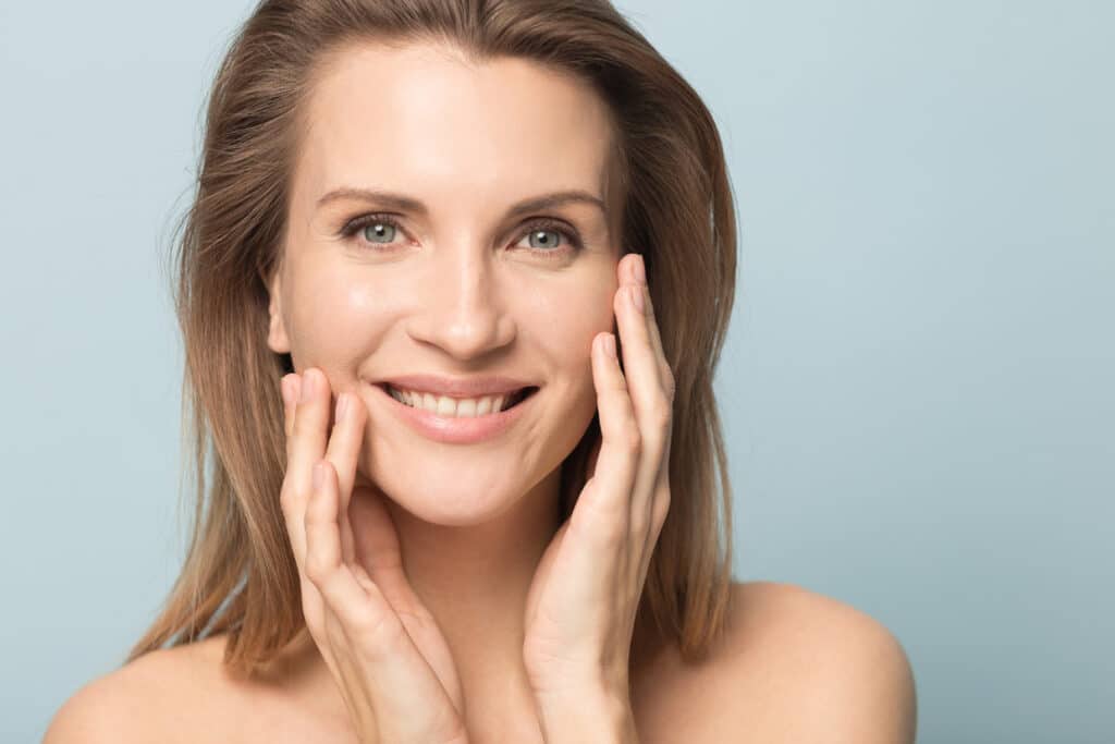 femme qui sourie avec une peau lisse et rayonnante